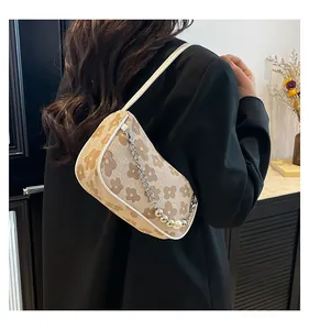 Detail of floral woven shoulder bag with pearl chain and vintage print on black blazer