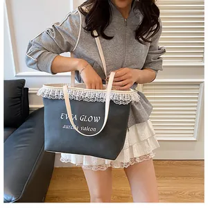 Détail du grand sac cabas gris avec dentelle blanche élégante et bandoulière chic