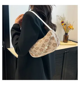 Detail of floral shoulder bag featuring retro daisy pattern and pearl chain pendant