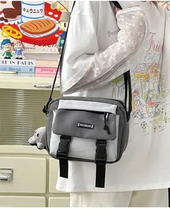 Detail of minimalist two-tone crossbody bag with buckles and a cute plush rabbit pendant