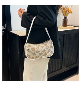 Detail of floral pattern beige shoulder bag with pearl metal chain and zipper closure
