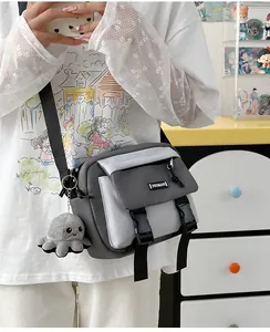 Detail of grey and white contrast crossbody bag with buckle closure and plush octopus charm
