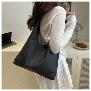 Minimalist large black tote bag shown on model in a modern office aesthetic setting