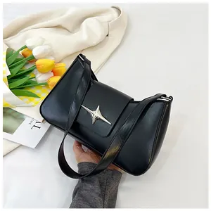 Détail du sac sous le bras en cuir noir avec boucle étoile argentée et forme rectangulaire chic