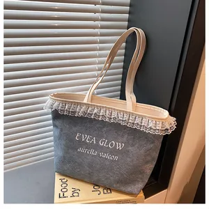 Détail d'un sac cabas en tissu gris avec bordure en dentelle blanche et lettrage EVEA GLOW