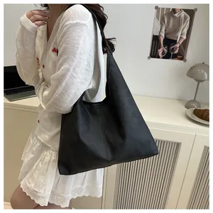 Minimalist large black hobo tote bag in matte PU leather shown in an office setting