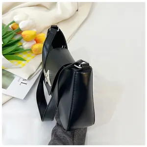 Détails d'un sac à bandoulière en cuir noir brillant avec boucle en métal argenté