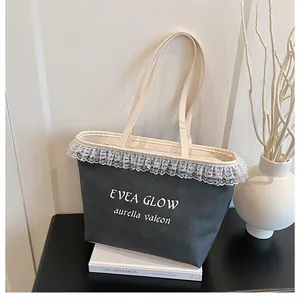 Détail du cabas en toile noire avec bordure en dentelle blanche et lettrage EVEA GLOW