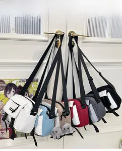 Detail view of colorful canvas messenger bags with buckle straps and plush octopus charms