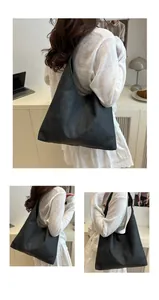 Detail of the soft matte synthetic leather texture and stitching on this black tote bag
