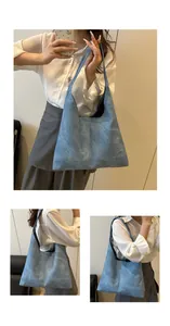 Detail of greyish blue large tote bag showing hobo style strap and matte leather texture