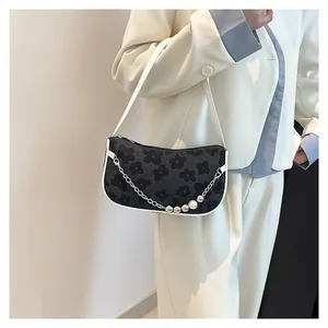 Floral shoulder bag with white leather strap and silver chain detail on model