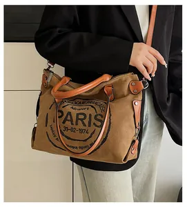 Detail of canvas tote bag with leather handles and vintage French letter printing