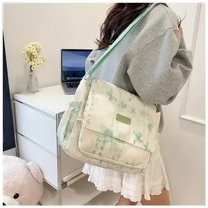Detail view of the nylon messenger bag with green butterfly print and adjustable side pocket