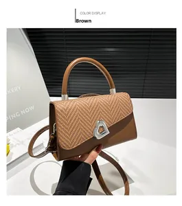 Detail van de bruine lederen handtas met gevlochten stro flap en zilveren hartgesp