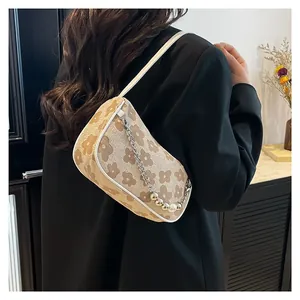 Vintage floral shoulder bag with khaki patterns and silver chain detail on model