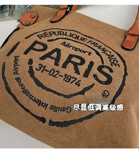 Detail of vintage canvas tote bag with Paris print and brown leather handle rivets