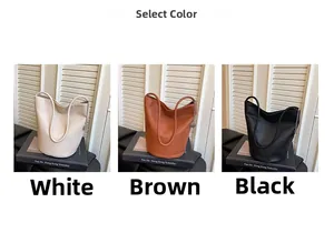 Détail de trois sacs seaux en cuir souple blanc, marron et noir avec décor de chaîne