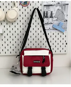 Detail of red and white crossbody bag with octopus plush charm and adjustable strap