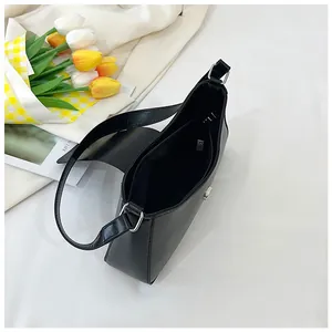 Vue de dessus d'un sac à bandoulière noir minimaliste avec doublure et poche zippée