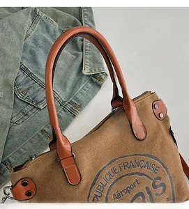 Detailed top view of brown canvas tote with leather handles and vintage Paris seal pattern