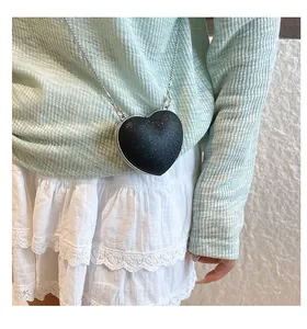 Détail du sac de soirée pailleté en forme de cœur avec bandoulière chaîne argentée