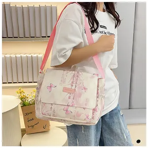 Detail of floral butterfly print on beige crossbody bag with pink shoulder strap