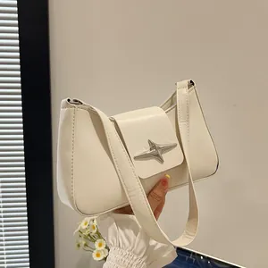 Vue détaillée de la boucle étoile argentée sur un sac à bandoulière en similicuir crème