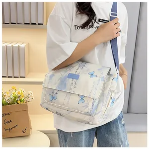 Detail of floral butterfly print on beige crossbody bag with blue adjustable strap