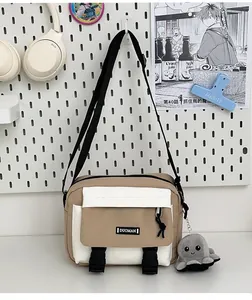 Detail view of khaki and white crossbody bag with octopus plush toy and adjustable strap