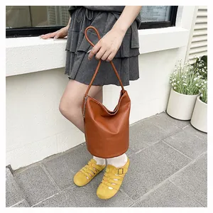 Detailed view of brown lychee grain bucket bag with silver chain and thin leather strap