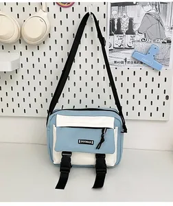 Detail of blue and white canvas crossbody bag with adjustable buckles and zip pocket