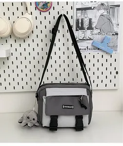 Close-up of contrast canvas crossbody bag with octopus plush charm and plastic buckle
