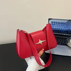 Détail du sac d'épaule en cuir rouge avec une boucle en métal argenté poli en étoile