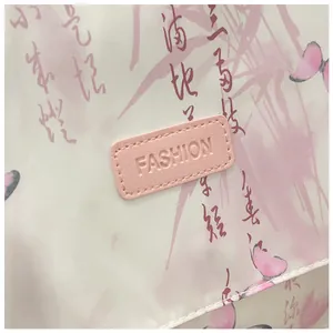 Detail of floral print crossbody bag featuring ink-style patterns and pink fashion patch