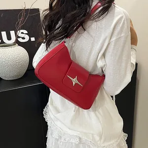 Détail du sac sous l'aisselle en cuir PU rouge avec un fermoir en métal en forme d'étoile