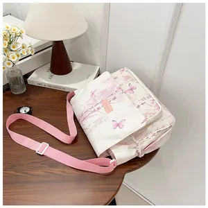 Detail showing the floral print canvas messenger bag with adjustable pink shoulder strap