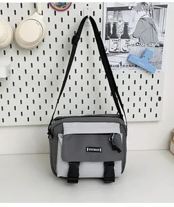 Detail view of neutral crossbody messenger bag with gray patchwork and adjustable strap