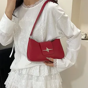 Détail du sac rouge en cuir mat avec boucle en forme d'étoile argentée élégante