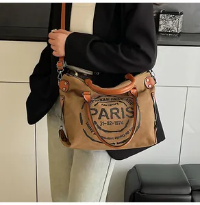 Detail of vintage canvas tote bag in khaki with Paris print and leather handles