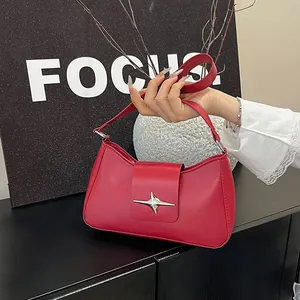 Détail macro du sac sous le bras rouge avec étoile argentée sur similicuir de luxe