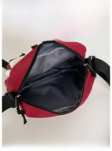 Internal view of the red nylon messenger bag showing spacious grey lining and zip closure