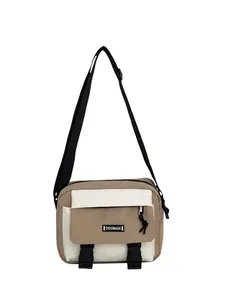 Detail of canvas messenger bag featuring khaki contrast panels and plastic buckles