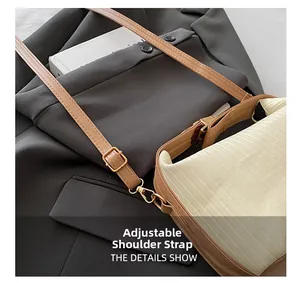 Détail de la bandoulière en cuir réglable et boucle en métal doré sur sac beige