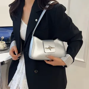 Sac à bandoulière argenté métallisé avec boucle étoile dans un cadre de bureau élégant
