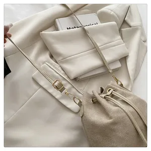 Detail of beige canvas bucket bag with leather drawstring and gold metal hardware