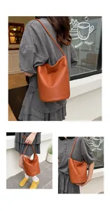 Detail of orange pebble leather bucket bag with silver chain strap and slouchy design