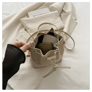 Detail of beige drawstring bucket bag interior capacity and premium fabric texture