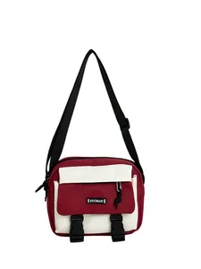 Detail view of red and white crossbody bag with adjustable strap and black buckles