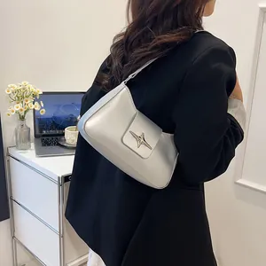 Vue détaillée d'un sac sous le bras en argent avec boucle en étoile sur un modèle